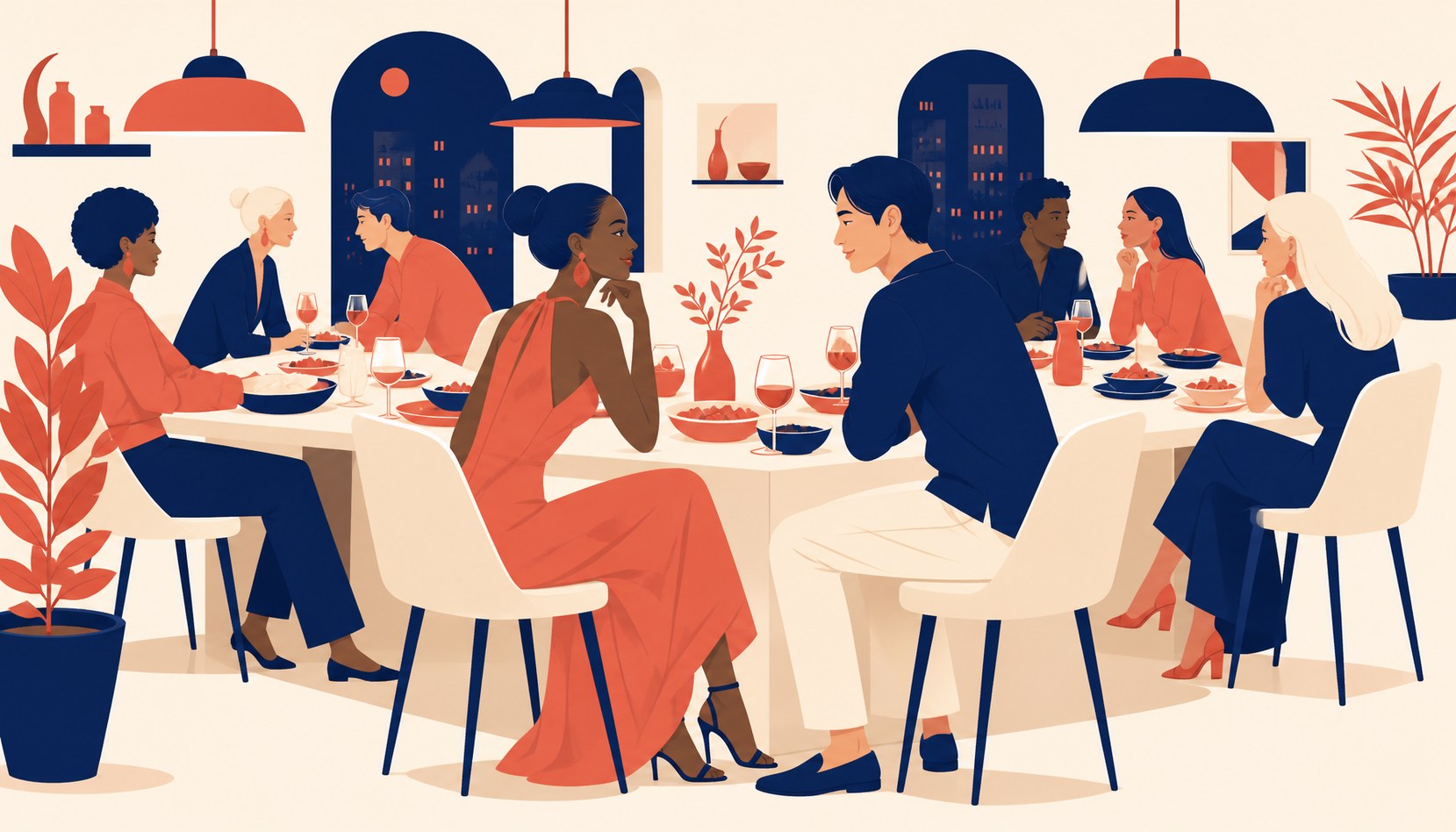 A long bistro table at night with people seated along both sides mid-conversation over shared dishes