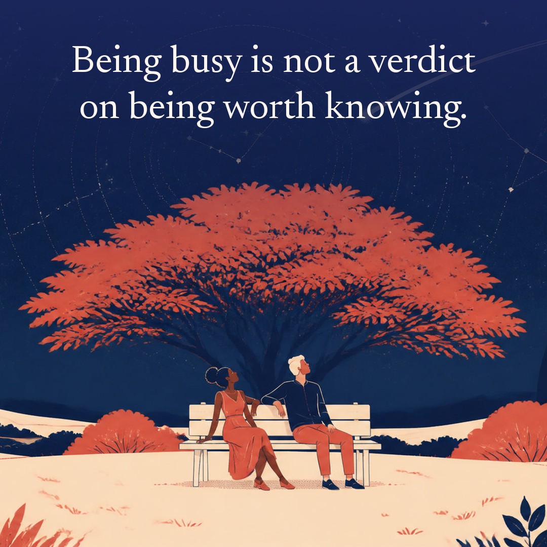 “Being busy is not a verdict on being worth knowing.” A couple, two adults sitting on a park bench beneath one large spreading tree at night, beneath a vast star field, delicate constellation lines, faint concentric orbital rings and one long comet arc across a deep navy night sky, with a crescent moon low at one side.