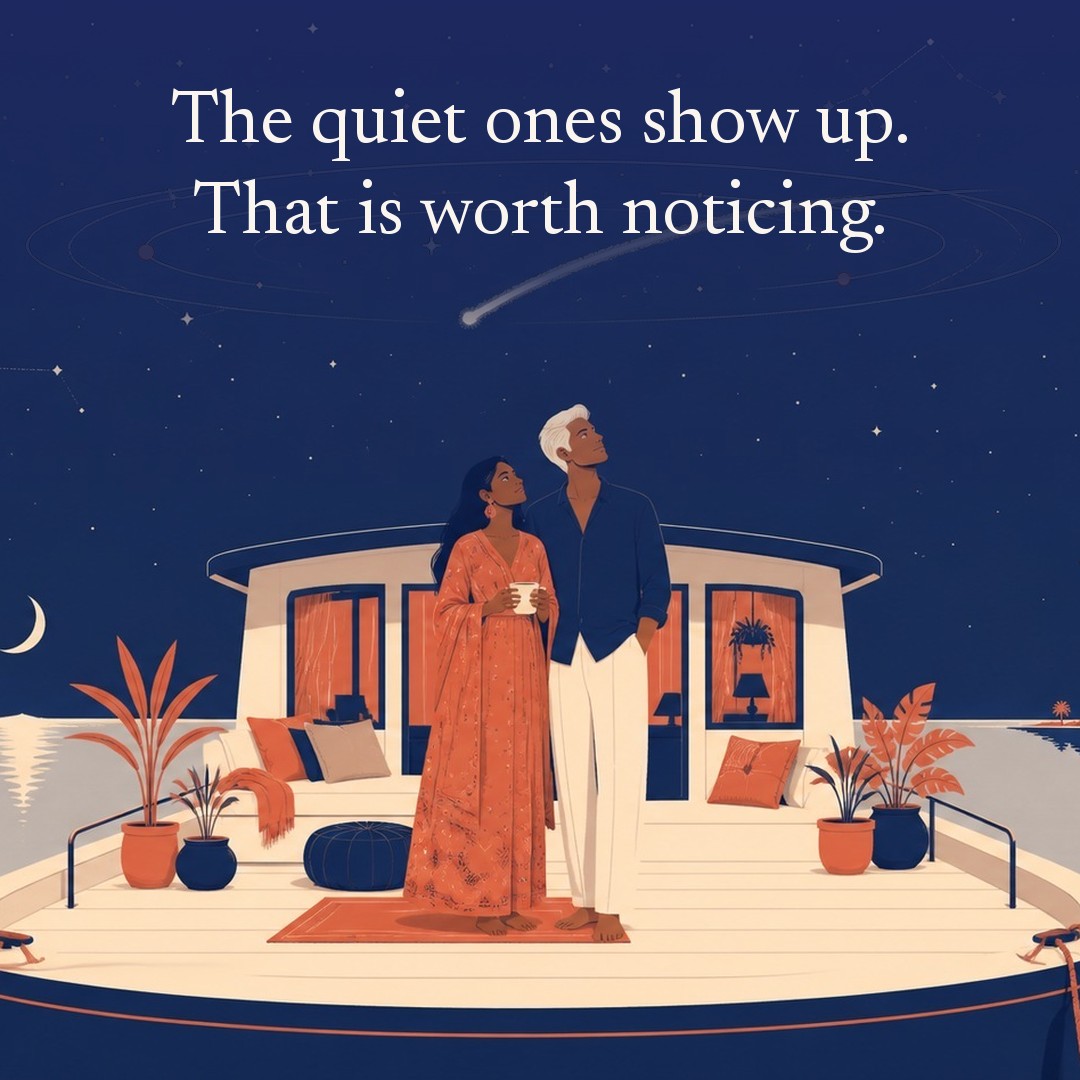 “The quiet ones show up. That is worth noticing.” A couple, two adults on the open deck of a houseboat moored at a quiet bank at night, beneath a vast star field, delicate constellation lines, faint concentric orbital rings and one long comet arc across a deep navy night sky, with a crescent moon low at one side.