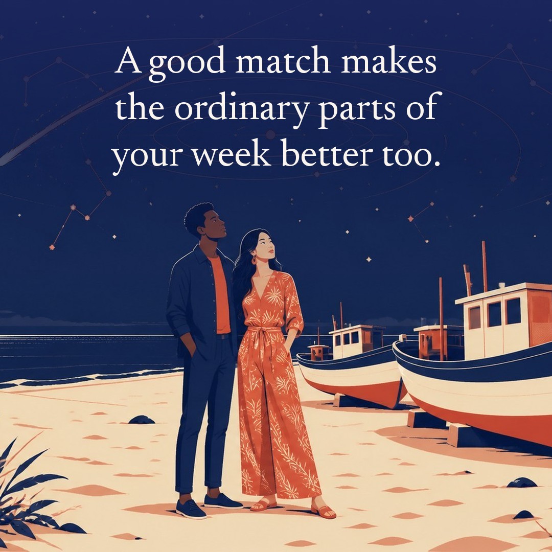 “A good match makes the ordinary parts of your week better too.” A couple, two adults beside a row of old fishing boats pulled up on a beach at night, beneath a vast star field, delicate constellation lines, faint concentric orbital rings and one long comet arc across a deep navy night sky, with a crescent moon low at one side.